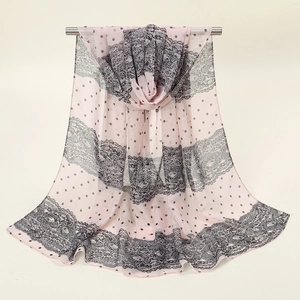 Vue détaillée d'une écharpe en mousseline rose clair à pois noirs et motifs dentelle