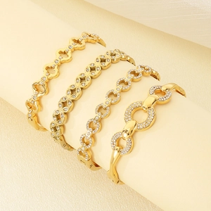 Detailed display of four gold-plated stainless steel bangles with sparkling crystals