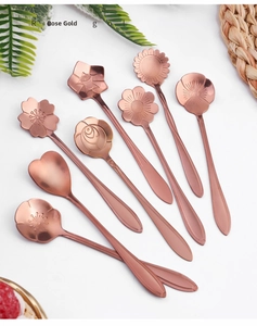 Macro view of eight rose gold stainless steel spoons featuring unique floral designs