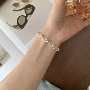 Close-up of a minimalist S925 sterling silver woven chain bracelet worn on a wrist
