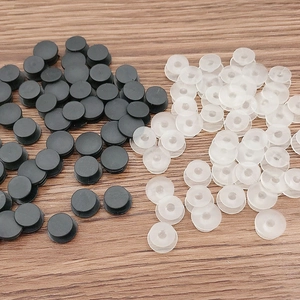 Black and transparent plastic plug connectors for garden shoes on wooden background