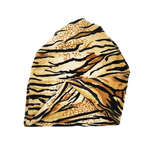 Detailed view of soft tiger print knit beanie featuring black and brown animal patterns