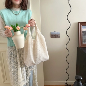 Detail of white floral lace crochet tote bag with intricate hollow out textures