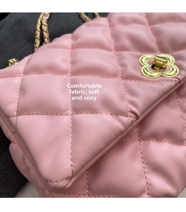 Detail of pink quilted leather bag with gold flower-shaped rotating lock and chain