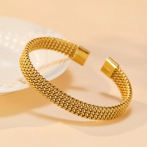 Detail of woven texture on gold-plated stainless steel cuff bracelet with smooth end caps