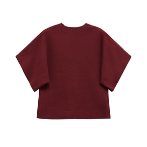 Detail of oversized burgundy V-neck knit top with drop shoulder and ribbed texture
