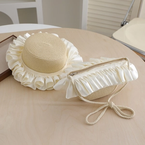 Detail of straw hat and crossbody bag set with cream satin ruffles and woven texture