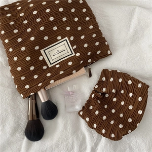 Close-up of brown polka dot pleated chiffon cosmetic bag set with PLEASANT TIME label