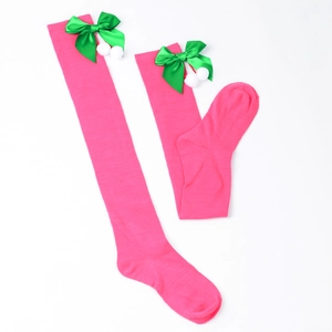 Detail of pink over-knee Christmas socks with green satin bow and white fluffy pom-poms