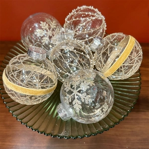 Sparkling gold lace Christmas ball ornaments set on a glass tray for holiday decor