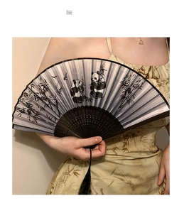 Detail of Chinese ink painting folding fan featuring pandas and black silk tassel