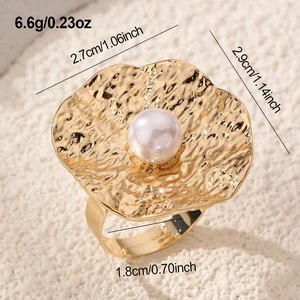 Detail view of vintage gold flower ring with pearl inlay and textured petal finish