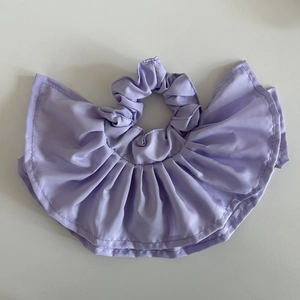 Close-up of light purple double-layer ruffled fabric scrunchie with glossy finish