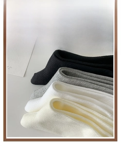 Gros plan de chaussettes en tricot côtelé en noir, gris, blanc et beige de style doux