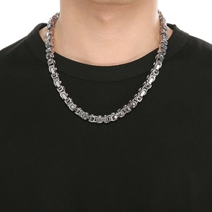 Close-up of silver Byzantine chain necklace worn by a model on white background