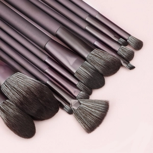 Detail of 12-piece purple makeup brush set showing soft bristles and matte handles