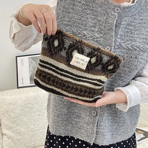 Close-up of fluffy geometric plush makeup bag featuring a colorful sozakka logo label