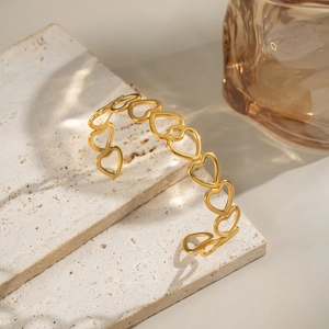 Polished 18K gold-plated stainless steel open cuff bracelet with hollow heart pattern