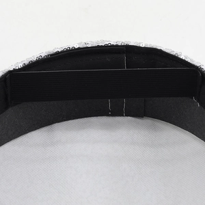 Macro detail of silver sequined party hat showing interior elastic band and stitching