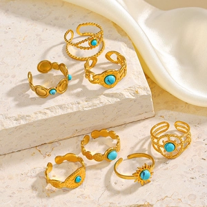 Bohemian gold ring set with turquoise stones displayed on stone and silk background