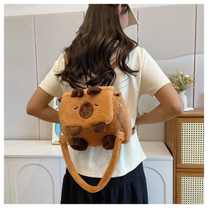 Cute brown plush capybara backpack with metal chain strap worn by a model in detail