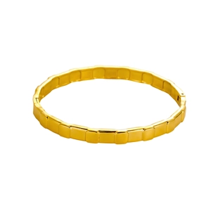 Detail of a gold-plated segmented link bracelet with polished geometric square textures