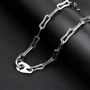 Detailed shot of silver stainless steel necklace with hollow irregular links on black leather