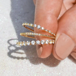 Detailed close-up of a three-piece gold ring set with sparkling zircon stones