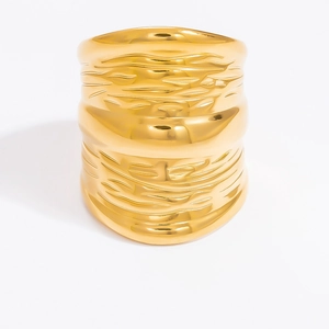 Detail shot of wide gold ring featuring bold hammered texture and bark-like finish