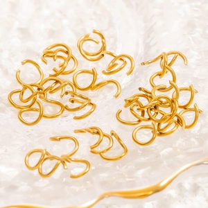 Macro shot of 18K gold plated open rings and jewelry connectors on a textured tray