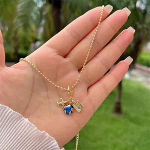 Λεπτομέρεια από επιχρυσωμένο κολιέ 18K με μενταγιόν αεροπλάνο, υδρόγειο και γραμματόσημο
