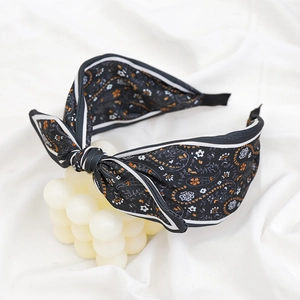 Detail of bohemian black cashew print fabric headband with a large bow decoration