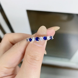 Macro shot of S925 sterling silver ring with blue and clear gemstones on a hand