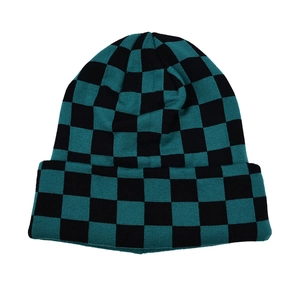 Detailed view of green and black checkerboard knit pattern on a winter beanie hat