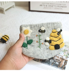 Detail of handmade wool felt bee coin purse showing 3D floral and bee applique