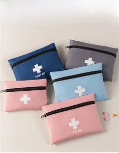 Flat lay of multiple color portable first aid bags with white cross and top zipper
