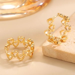 Detailansicht goldener Herz-Ohrringe mit poliertem Metall-Finish und Klappverschluss