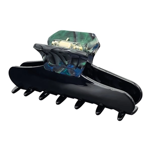 Detailed view of elegant acetate hair claw clip with dark marble texture and metal spring