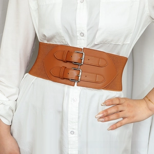 Detail view of brown elastic wide belt with double buckle design on a white shirt