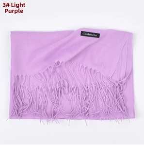 Detail of light purple cashmere scarf featuring long fringe and a classic fabric label