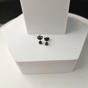 Detail view of matte black 316L stainless steel stud earrings with butterfly backings