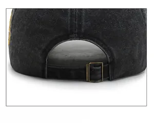 Detail of vintage copper adjustable buckle on washed black denim baseball cap