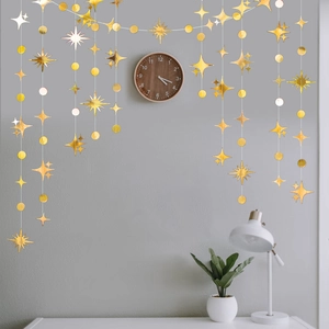 Ghirlanda dorata con stelle e cerchi appesa sopra una scrivania per decorazione interna