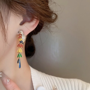 Macro view of colorful parrot earrings with gold plating and vibrant enamel details