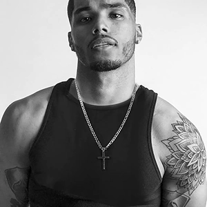 Men's stainless steel Cuban link chain with cross pendant shown on male model
