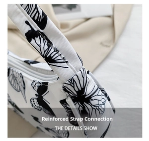 Close-up of reinforced shoulder strap stitching and butterfly print on the white bag