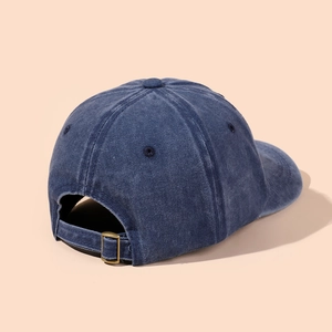 Detail of vintage copper buckle and adjustable strap on washed navy baseball cap