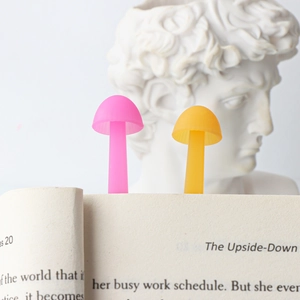 Creative mushroom silicone bookmarks in pink and yellow shown inside an open book