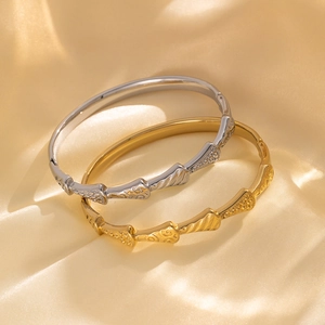Luxurious fan-shaped titanium steel bangles in gold and silver on champagne silk fabric