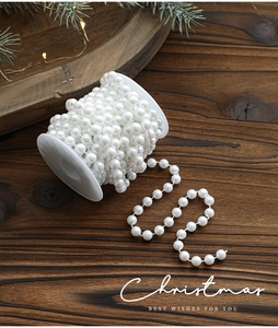 Close-up of white faux pearl bead garland on a reel for Christmas tree DIY decoration